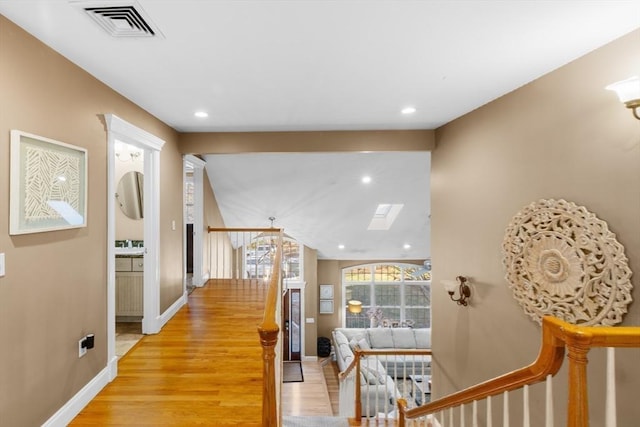 hall with light hardwood / wood-style floors and sink