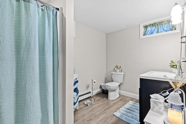 bathroom featuring vanity, wood-type flooring, a baseboard heating unit, and toilet