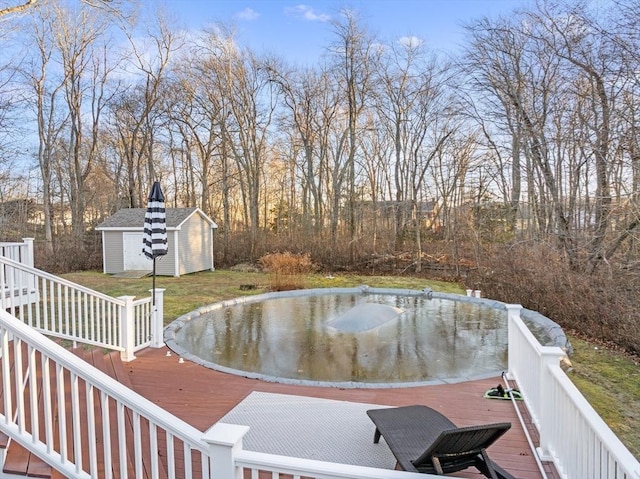 view of pool with a deck and a storage unit