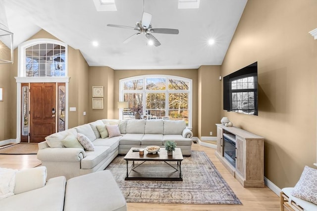 living room featuring light hardwood / wood-style flooring, ceiling fan, and lofted ceiling