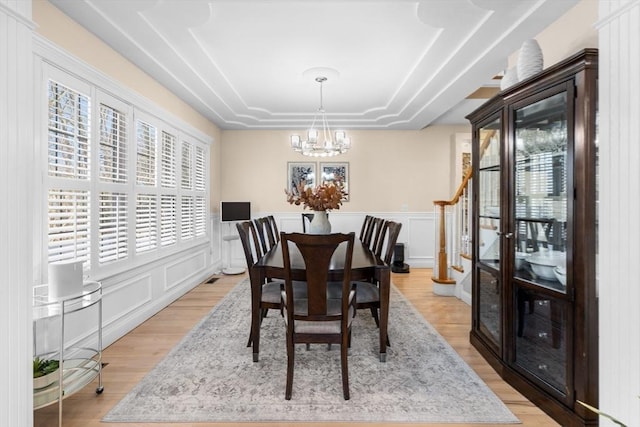 dining space with light wood-type flooring and a notable chandelier