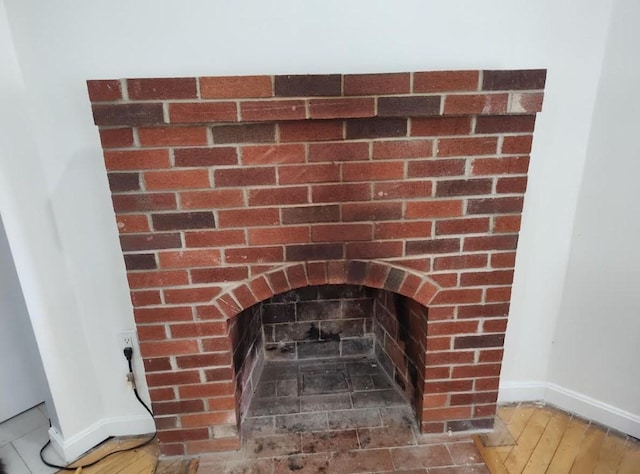 interior details featuring baseboards, wood finished floors, and a fireplace