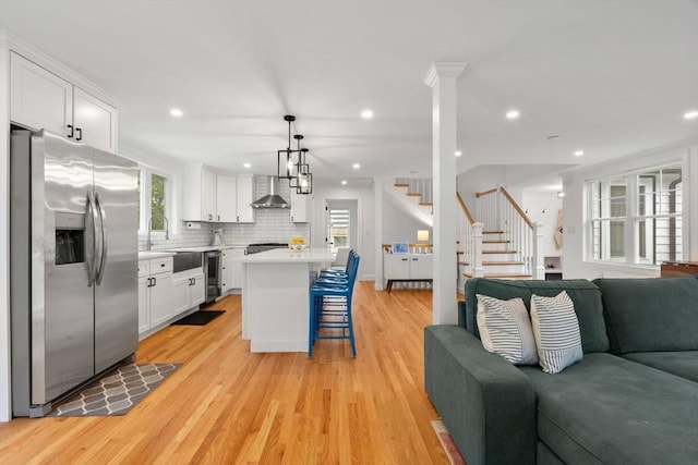 21 Pembrook Rd, North Andover, MA 01845 - kitchen featuring appliances with stainless steel finishes, wall chimney range hood, open floor plan, a kitchen bar, and recessed lighting
