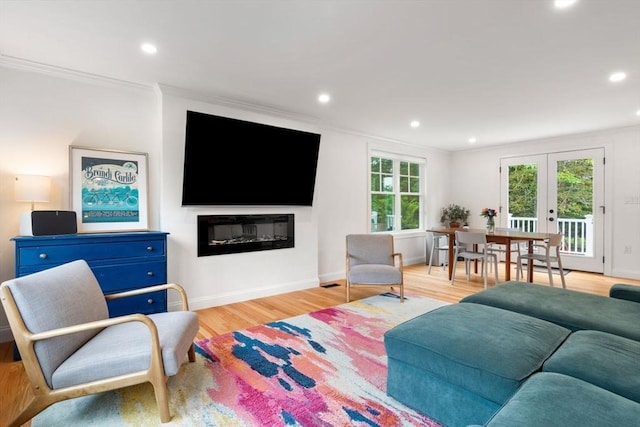 21 Pembrook Rd, North Andover, MA 01845 - living area with ornamental molding, french doors, recessed lighting, a glass covered fireplace, and light wood-style floors