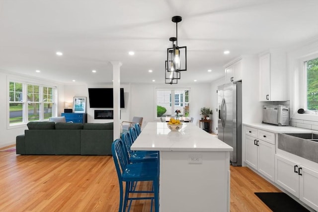 21 Pembrook Rd, North Andover, MA 01845 - kitchen with stainless steel fridge, a center island, light wood-style flooring, white cabinets, and recessed lighting