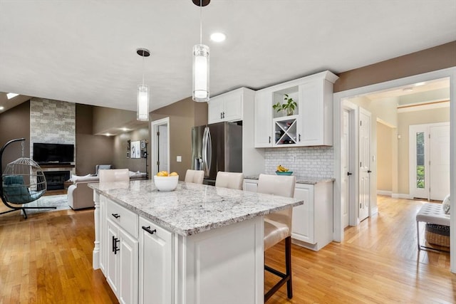 10 Primrose Ln, Westborough, MA 01581 - kitchen with stainless steel fridge, light wood-style floors, white cabinetry, and decorative backsplash