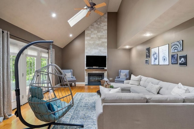10 Primrose Ln, Westborough, MA 01581 - living area featuring wood finished floors, high vaulted ceiling, ceiling fan, a skylight, and a stone fireplace