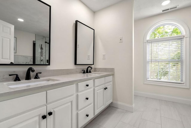 10 Primrose Ln, Westborough, MA 01581 - bathroom featuring baseboards, double vanity, an enclosed shower, and recessed lighting