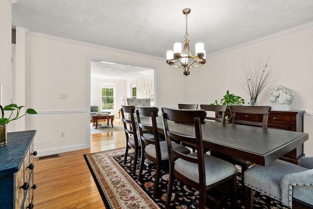 10 Primrose Ln, Westborough, MA 01581 - dining area with light wood finished floors, a chandelier, crown molding, and baseboards