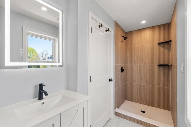 bathroom featuring recessed lighting, a tile shower, and vanity