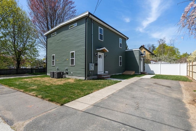exterior space with a fenced backyard, central AC, a yard, and entry steps