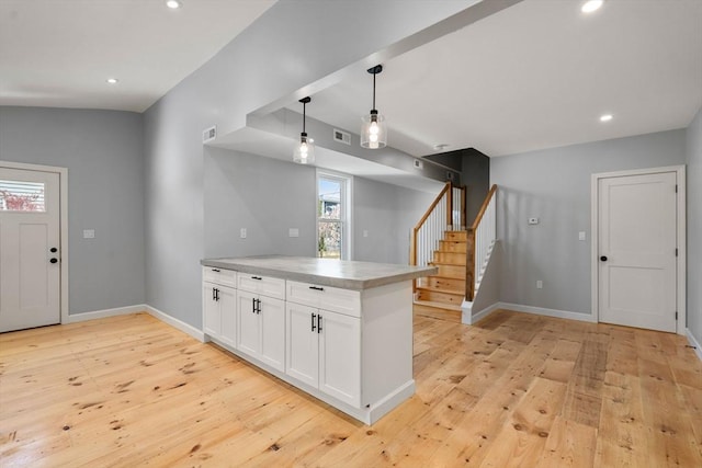 kitchen with a peninsula, baseboards, light wood-type flooring, recessed lighting, and white cabinets