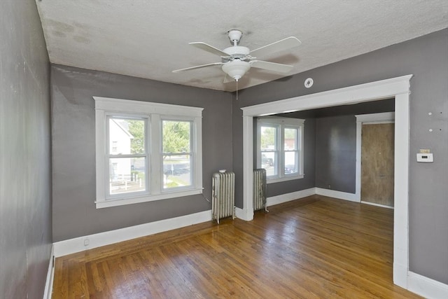 16 Worthen St, West Springfield, MA 01089 - unfurnished room featuring radiator heating unit, wood finished floors, a ceiling fan, and a textured ceiling
