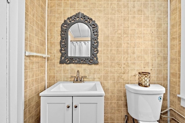 full bath featuring vanity, tile walls, and toilet