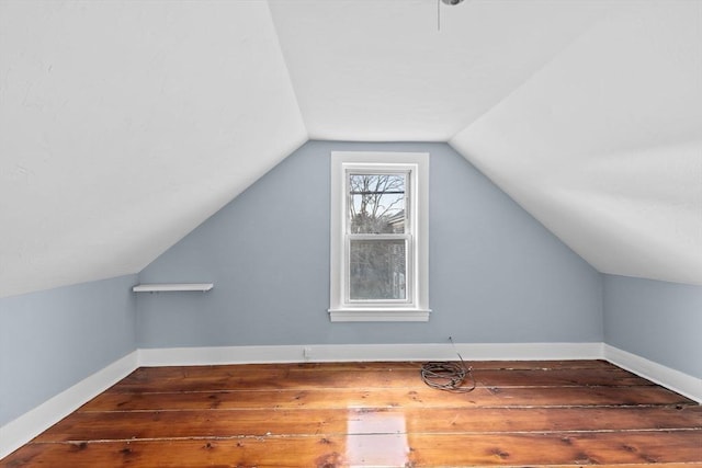 additional living space with vaulted ceiling, baseboards, and wood-type flooring