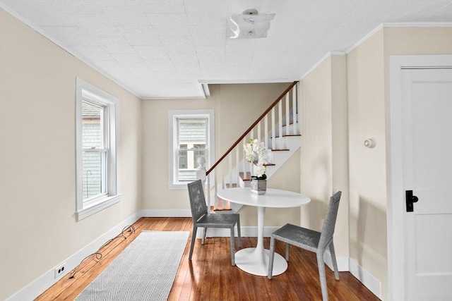 interior space featuring baseboards, wood-type flooring, stairs, and crown molding