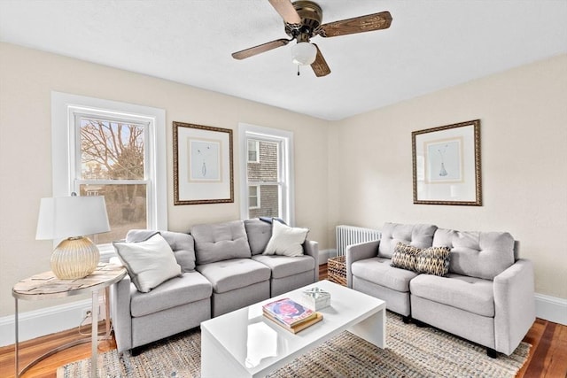 living room featuring a ceiling fan, wood finished floors, and baseboards