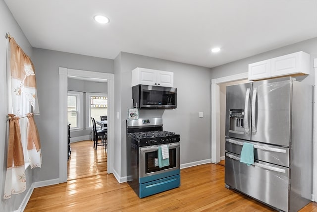 kitchen with light wood-type flooring, white cabinetry, and stainless steel appliances