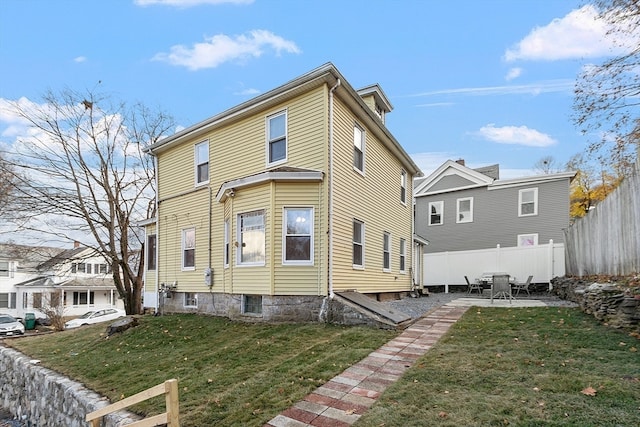 rear view of house featuring a yard and a patio area