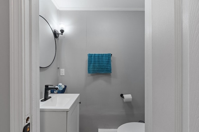 bathroom with vanity, toilet, and crown molding