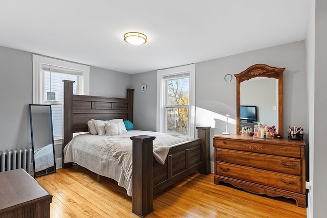 bedroom with light wood-type flooring and radiator heating unit