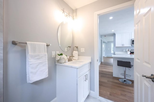 18 Beaumont Rd, Worcester, MA 01604 - bathroom featuring wood finished floors, vanity, baseboards, a baseboard heating unit, and recessed lighting