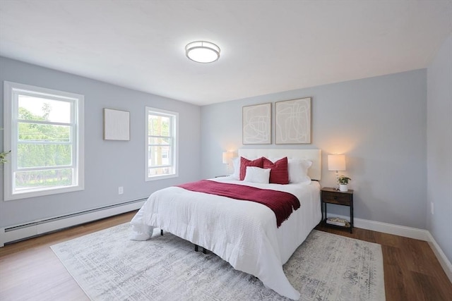18 Beaumont Rd, Worcester, MA 01604 - bedroom featuring multiple windows, wood finished floors, a baseboard heating unit, and baseboards