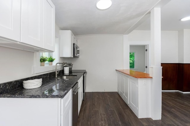 147 Fairmount Ave, Lynn, MA 01905 - kitchen featuring stainless steel appliances, dark wood-style floors, white cabinets, and dark stone countertops