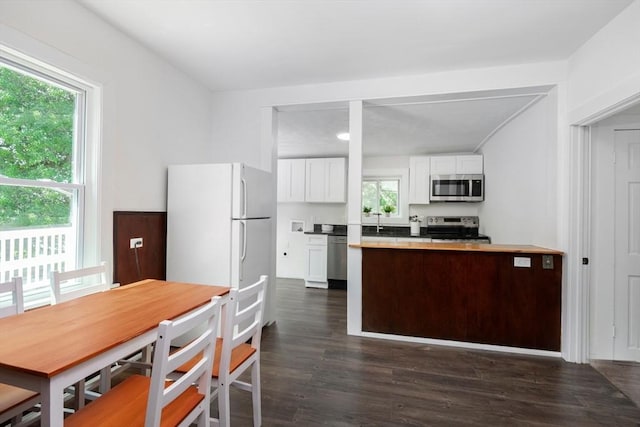 147 Fairmount Ave, Lynn, MA 01905 - kitchen with stainless steel appliances, white cabinetry, dark wood-style flooring, light countertops, and a peninsula