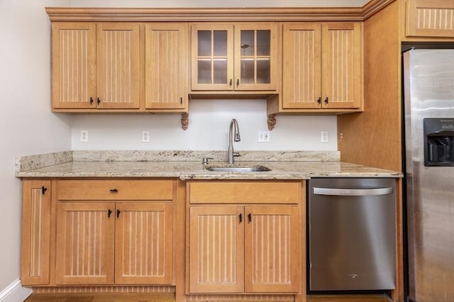 kitchen featuring light stone counters, sink, and appliances with stainless steel finishes