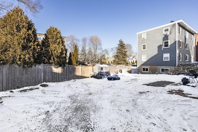 yard layered in snow featuring a storage shed