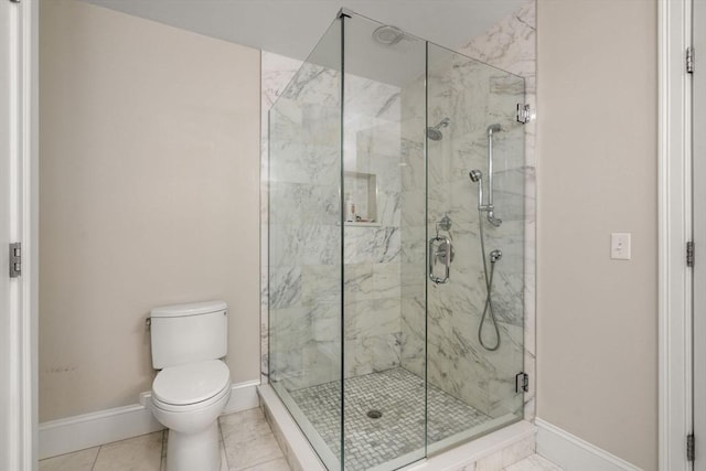 full bathroom featuring tile patterned floors, a marble finish shower, baseboards, and toilet