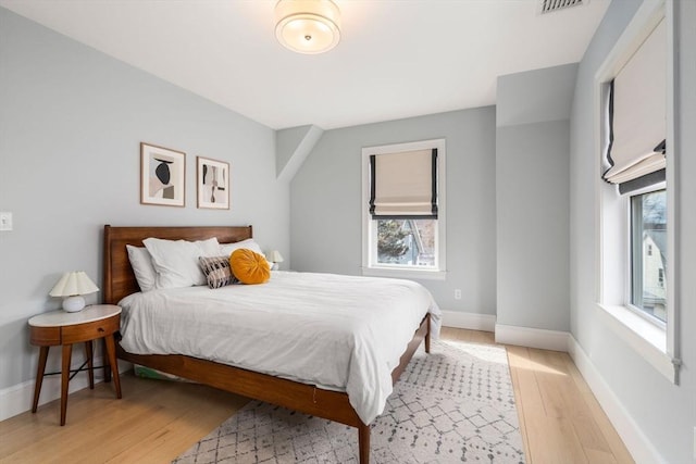 bedroom with visible vents, baseboards, and light wood-style floors