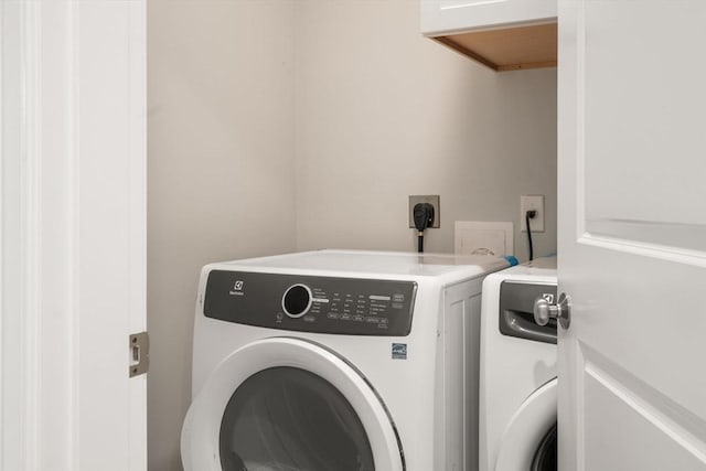 laundry area with cabinet space and separate washer and dryer