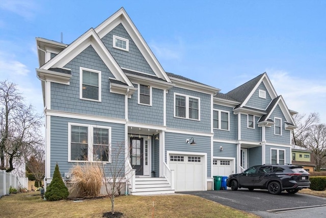 view of front facade featuring an attached garage, driveway, and fence