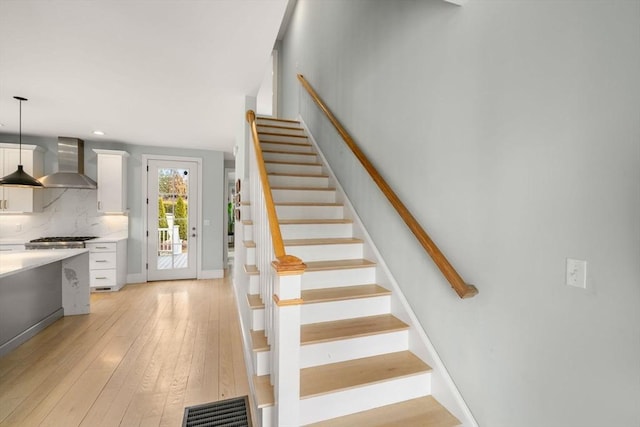 stairs with visible vents, baseboards, and hardwood / wood-style floors