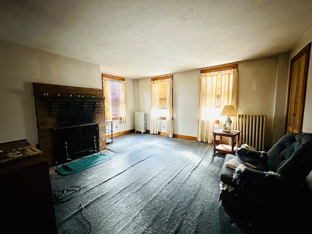 living area with a brick fireplace, radiator heating unit, a textured ceiling, and carpet flooring