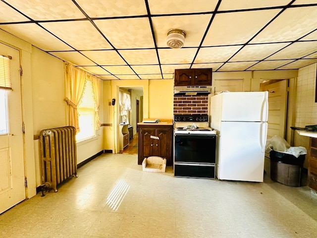 kitchen with dark brown cabinetry, white appliances, and radiator heating unit