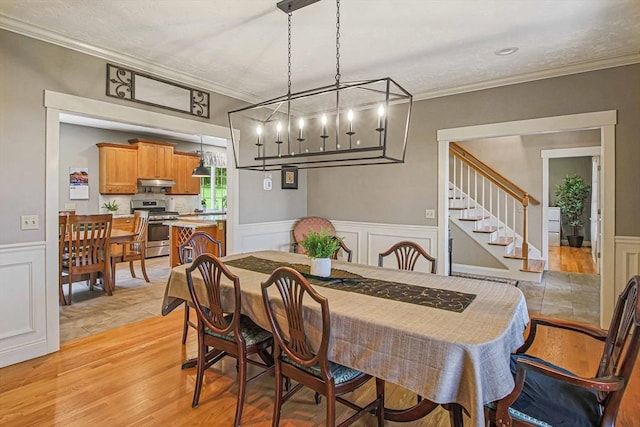 27 Southwick Rd, Sutton, MA 01590 - dining space with crown molding, a wainscoted wall, a chandelier, stairway, and light wood-type flooring