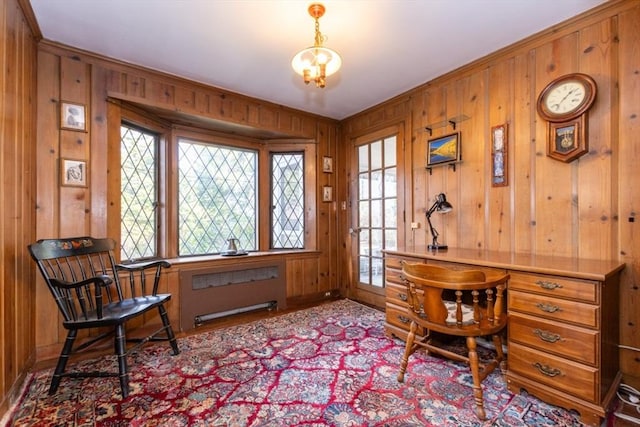 home office featuring radiator heating unit, baseboards, ornamental molding, and wood walls
