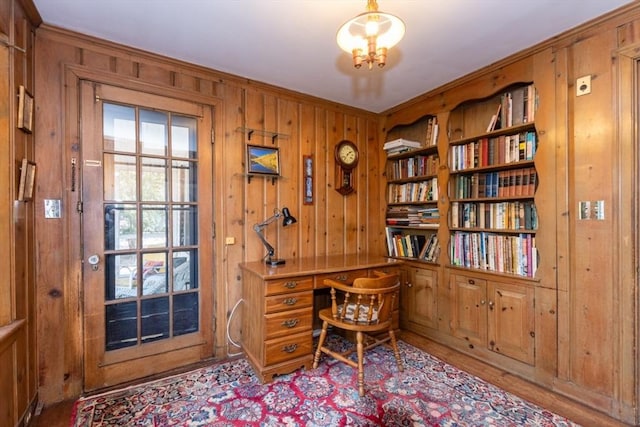 office area featuring crown molding, wood walls, and a notable chandelier