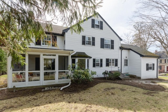 back of property with a sunroom and roof with shingles