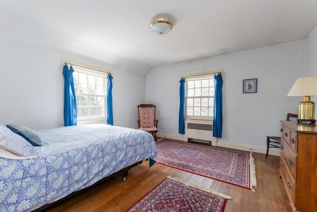 bedroom with lofted ceiling and wood finished floors