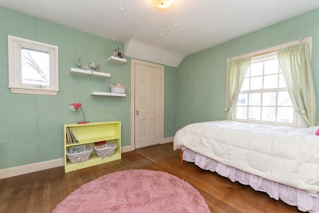 bedroom with baseboards, vaulted ceiling, and wood finished floors