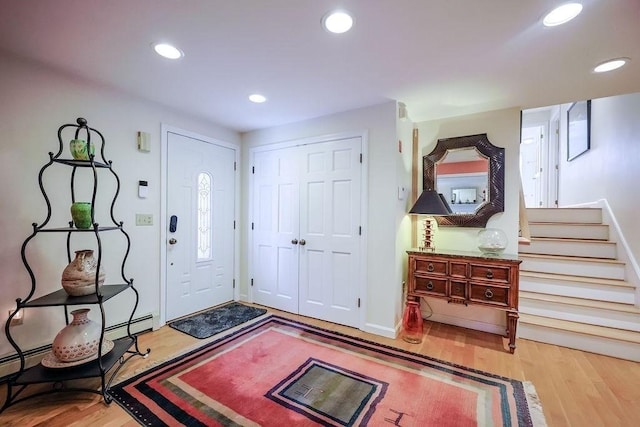 foyer entrance featuring baseboards, stairway, wood finished floors, and recessed lighting