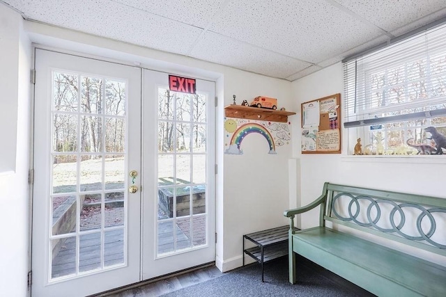 doorway with french doors, a drop ceiling, and baseboards