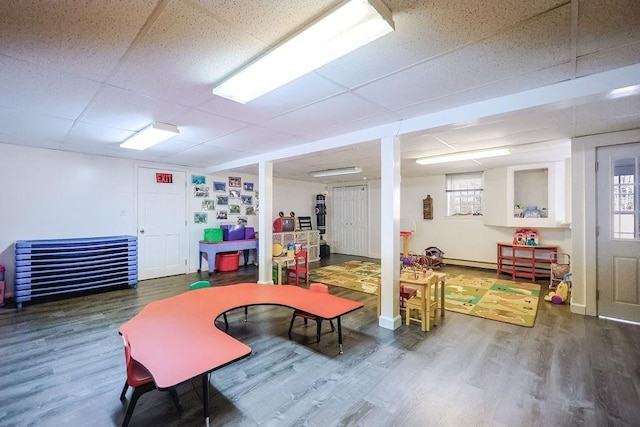 playroom featuring a paneled ceiling, a healthy amount of sunlight, and wood finished floors