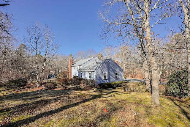 view of home's exterior with a yard and a chimney