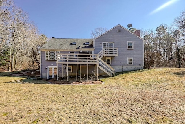 rear view of property with a yard, a chimney, a wooden deck, and stairs