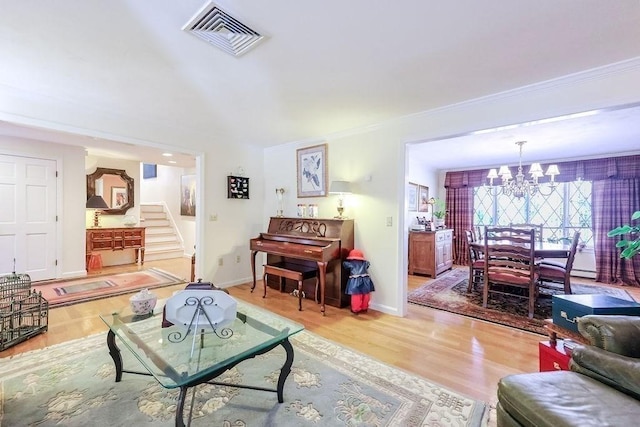 living room with a chandelier, stairway, wood finished floors, and visible vents